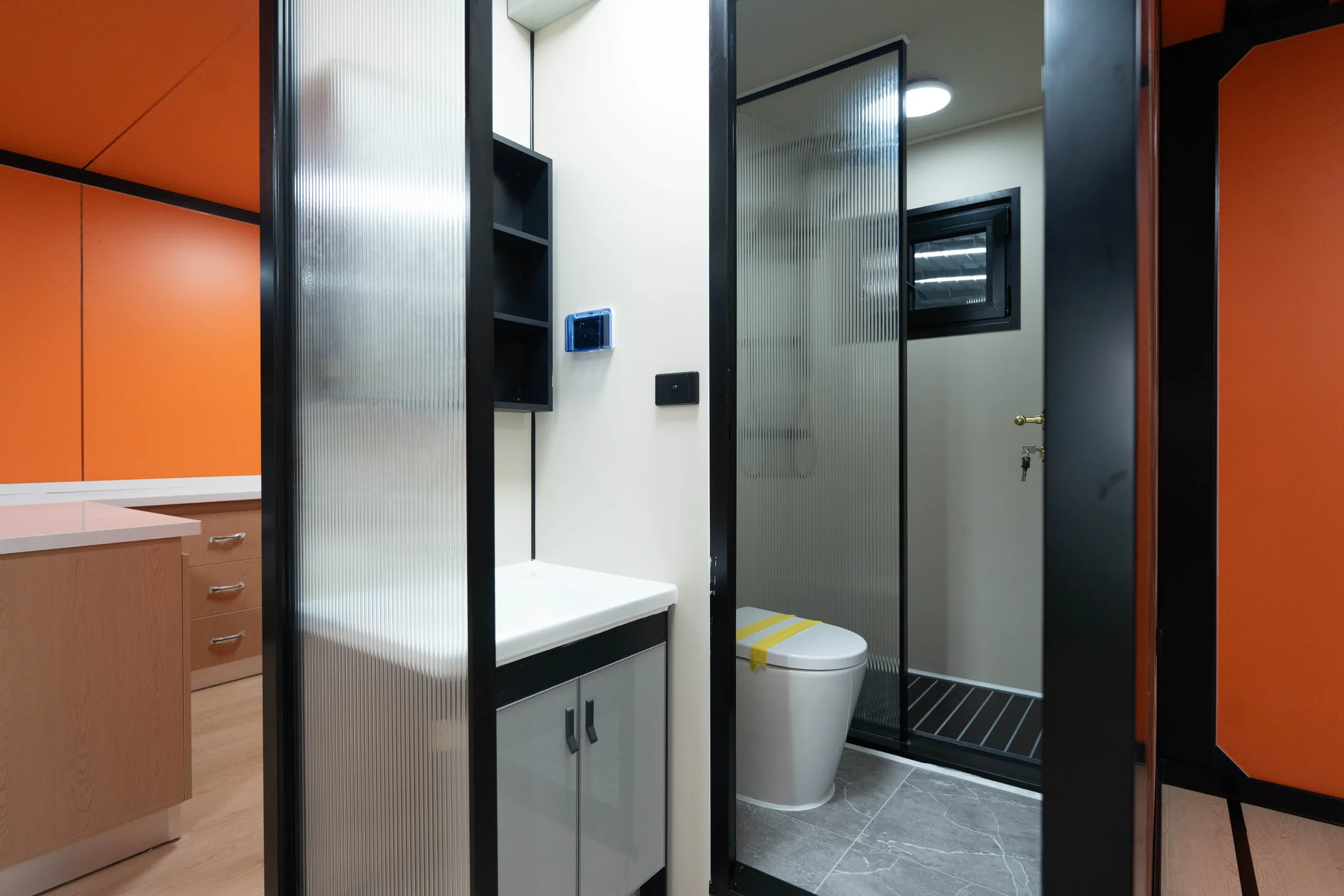 Bathroom entrance with vanity, toilet and shower inside the expandable house