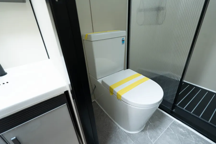Fitted toilet beside the shower partition