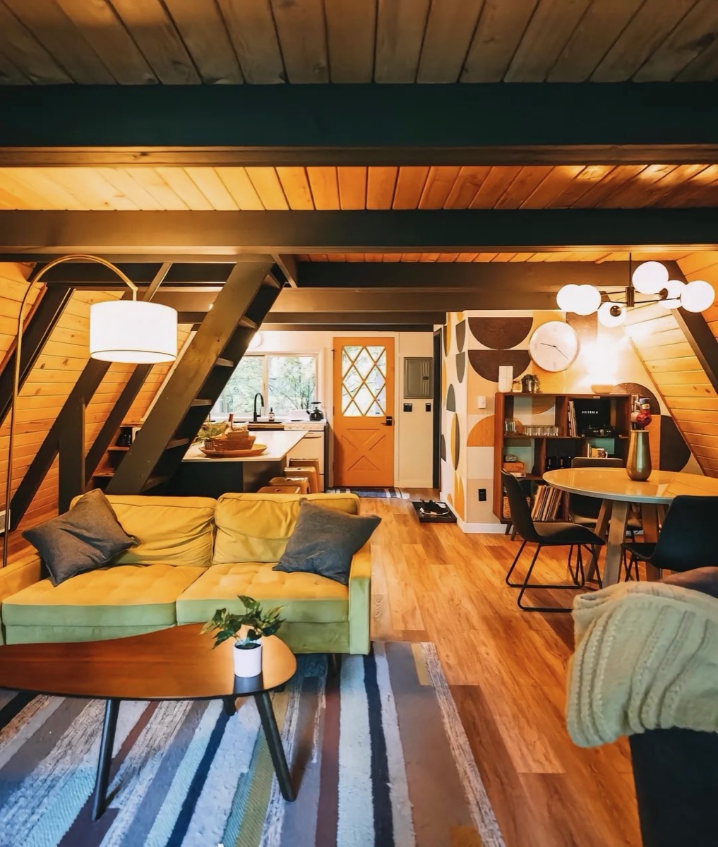 Warm open-plan living and dining area in an A-frame cabin