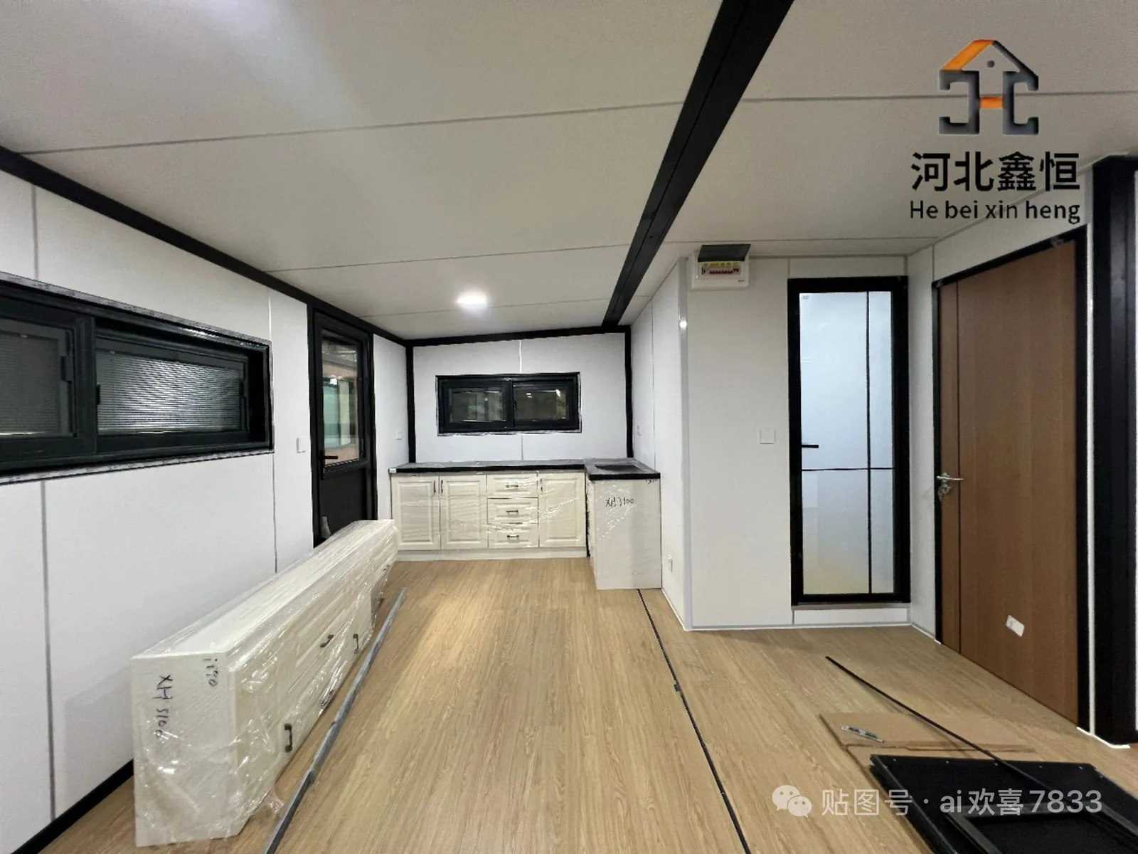 Factory-finished expandable house interior with cabinet run, windows and wood-look flooring