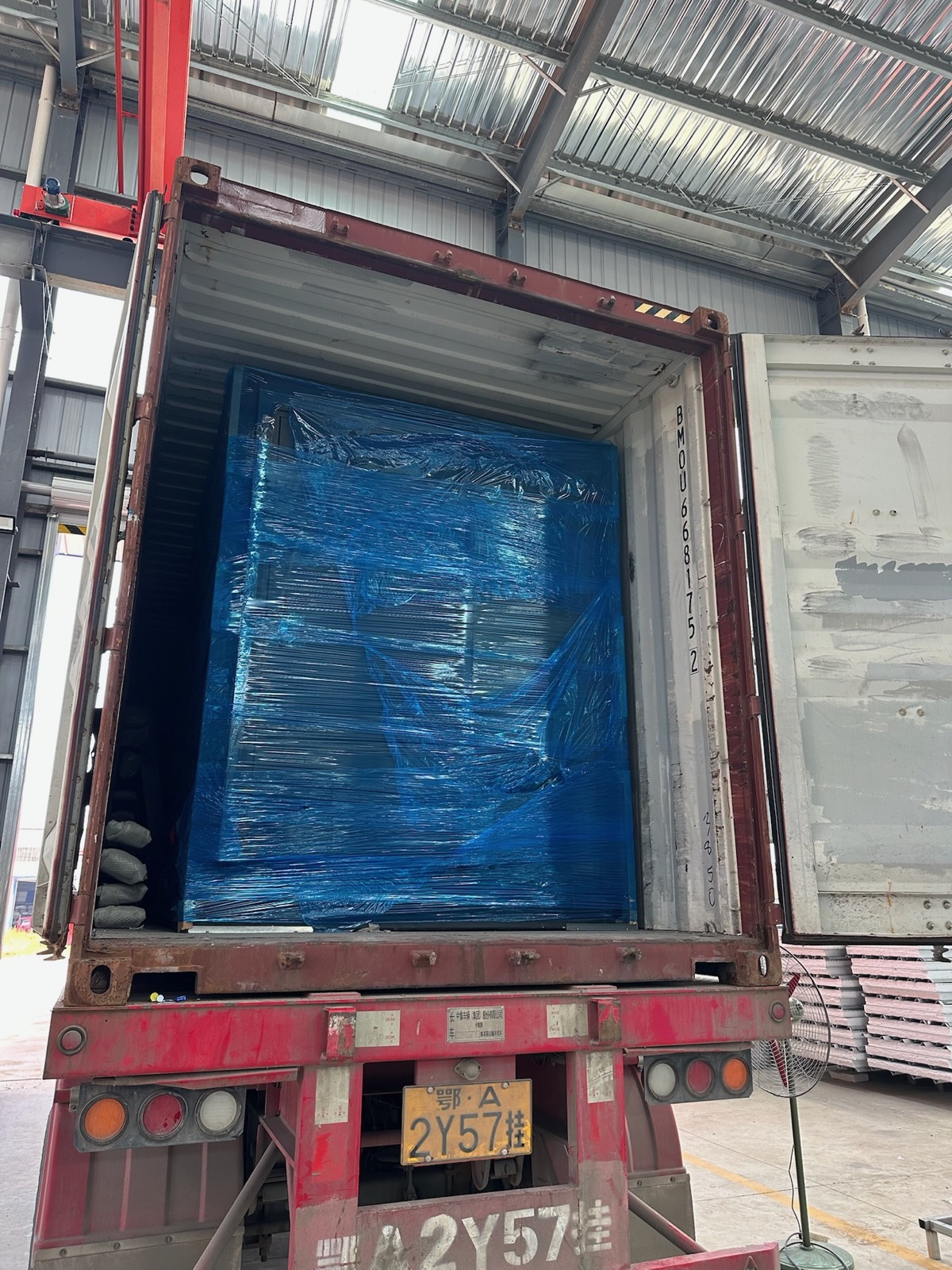 Wrapped modular housing unit protected inside a shipping container