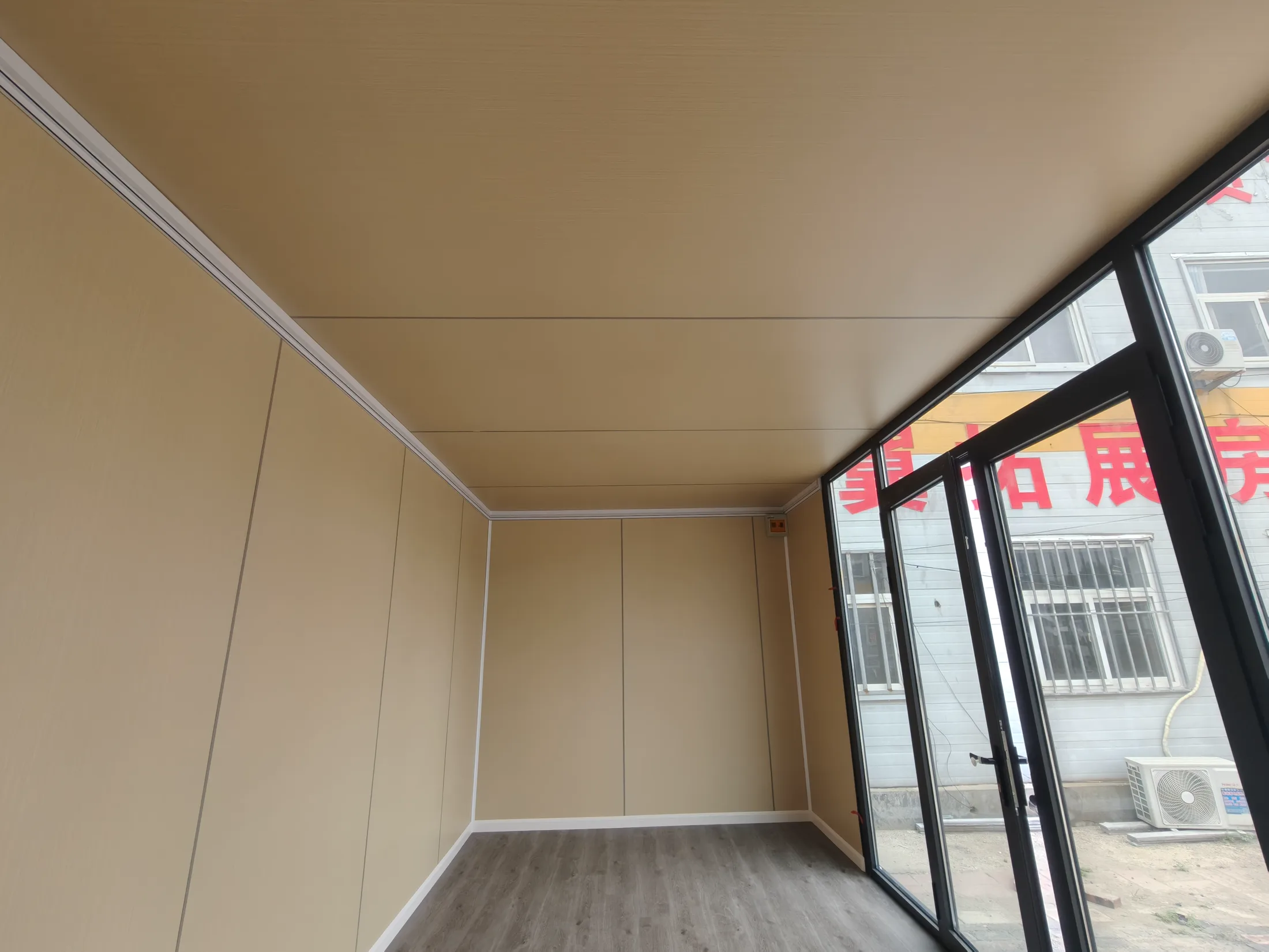 Apple cabin interior showing a large glazed entrance and warm neutral panels
