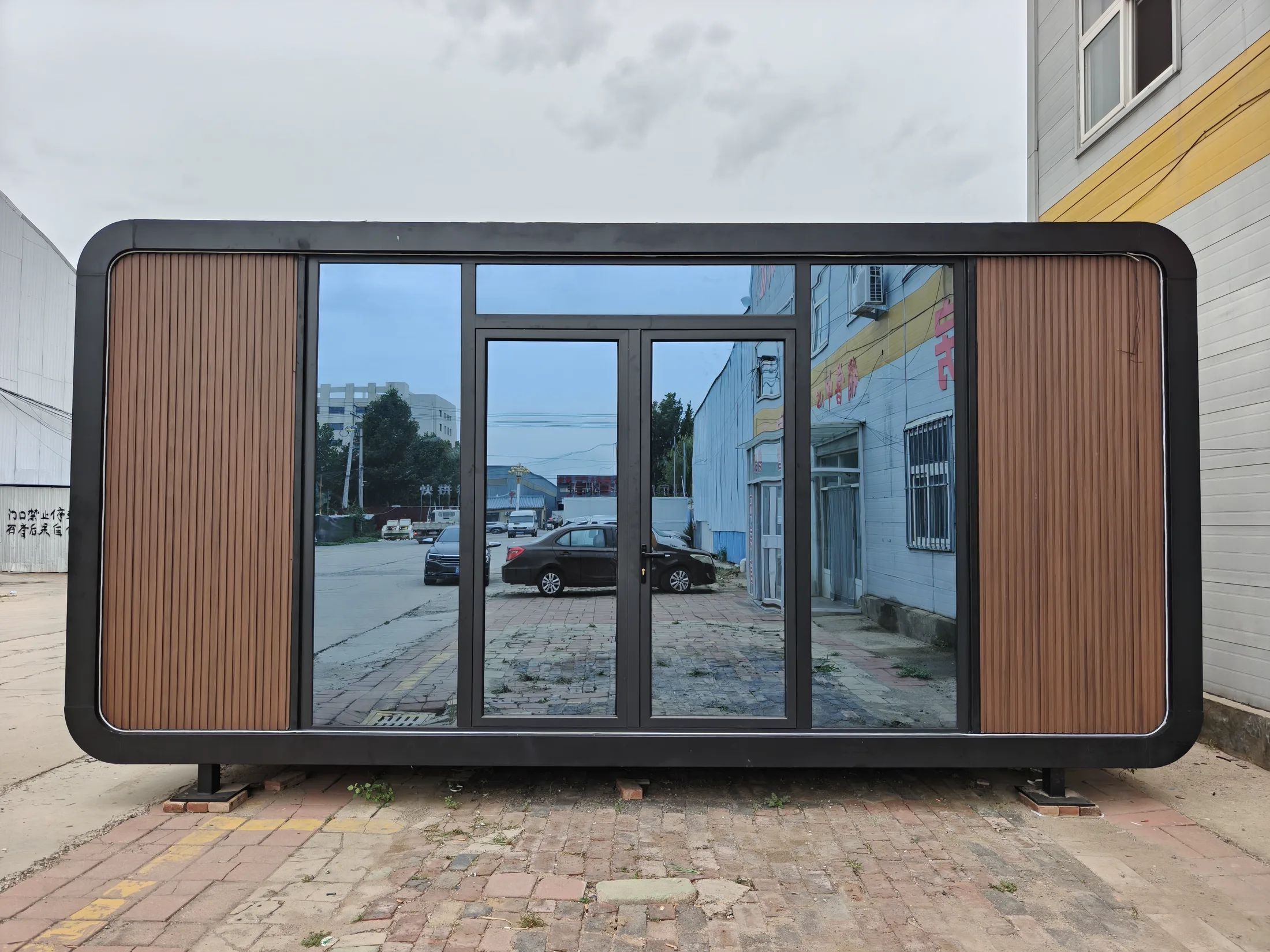 Real multipurpose apple cabin with panoramic glazing and wood-look facade