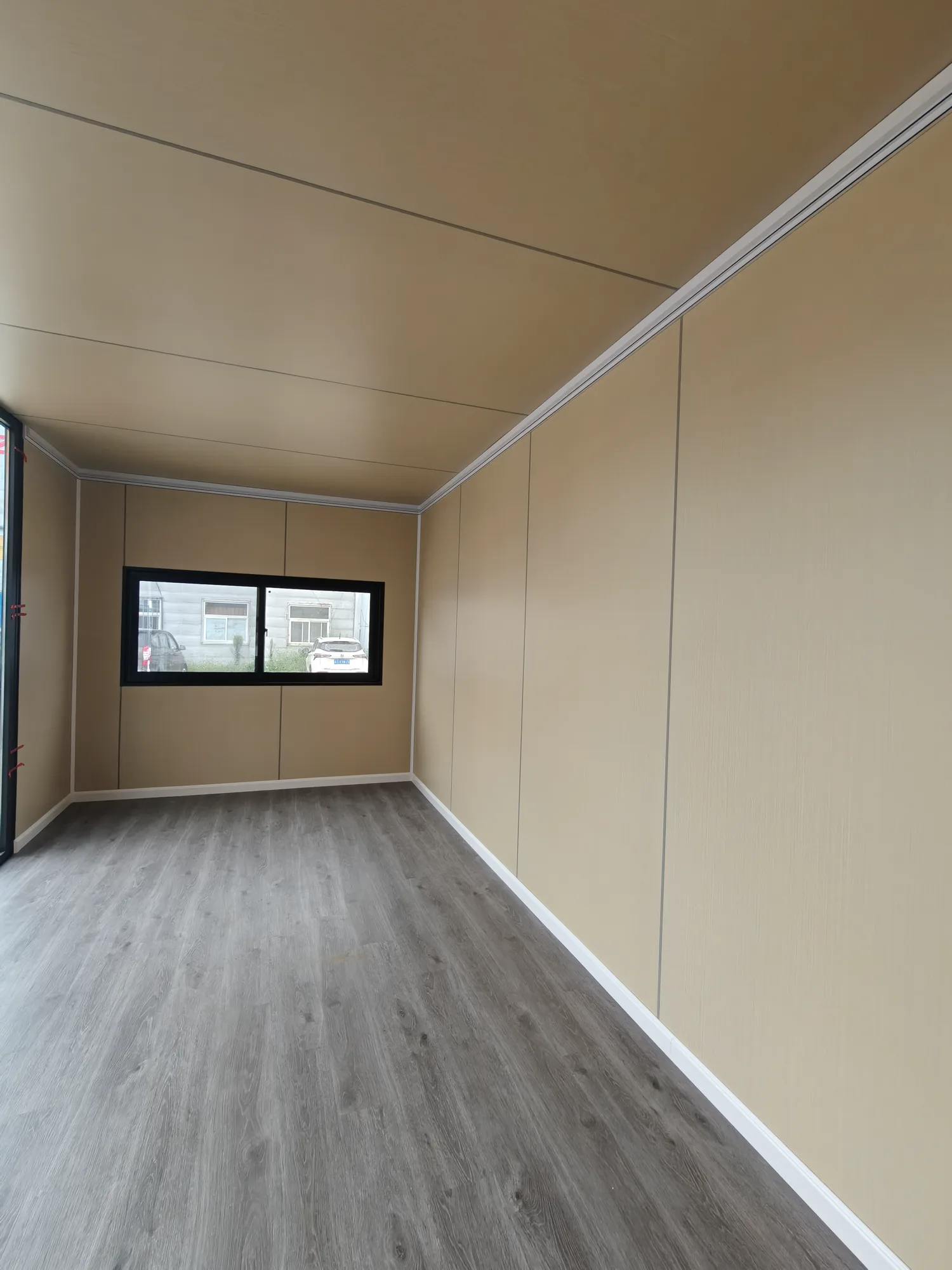 Long apple cabin interior with finished walls, flooring and an end window