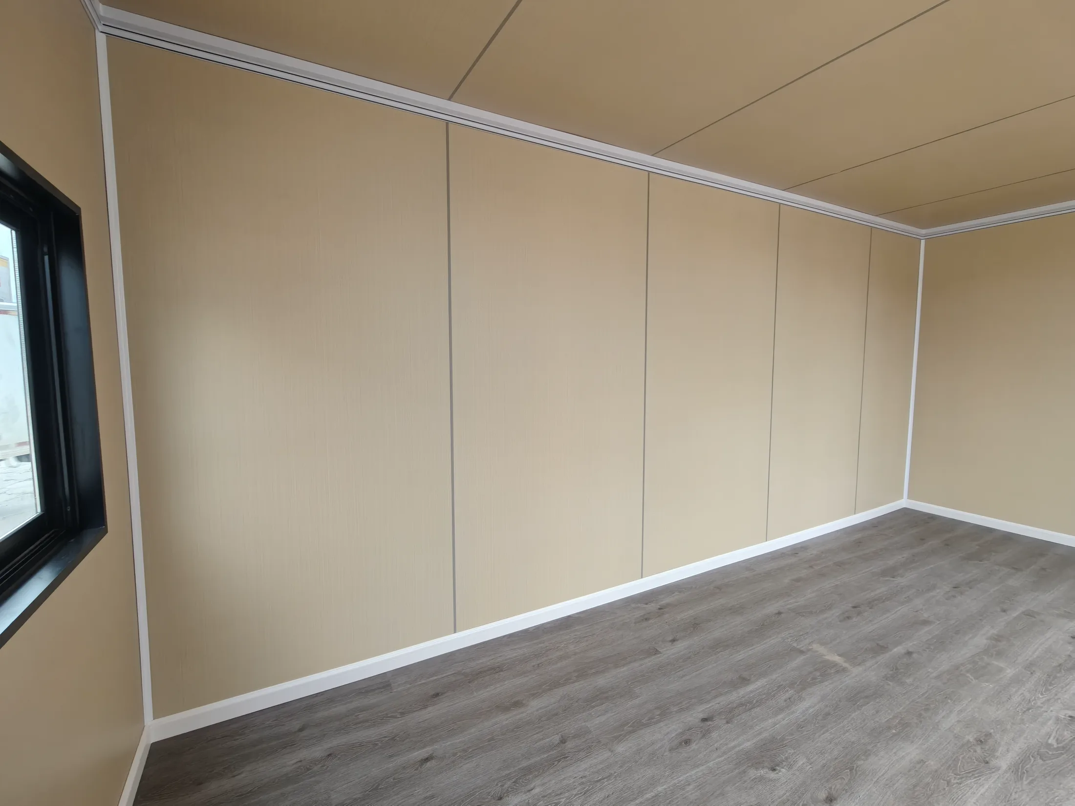 Close interior view of apple cabin wall panels, white trim and grey wood-look flooring