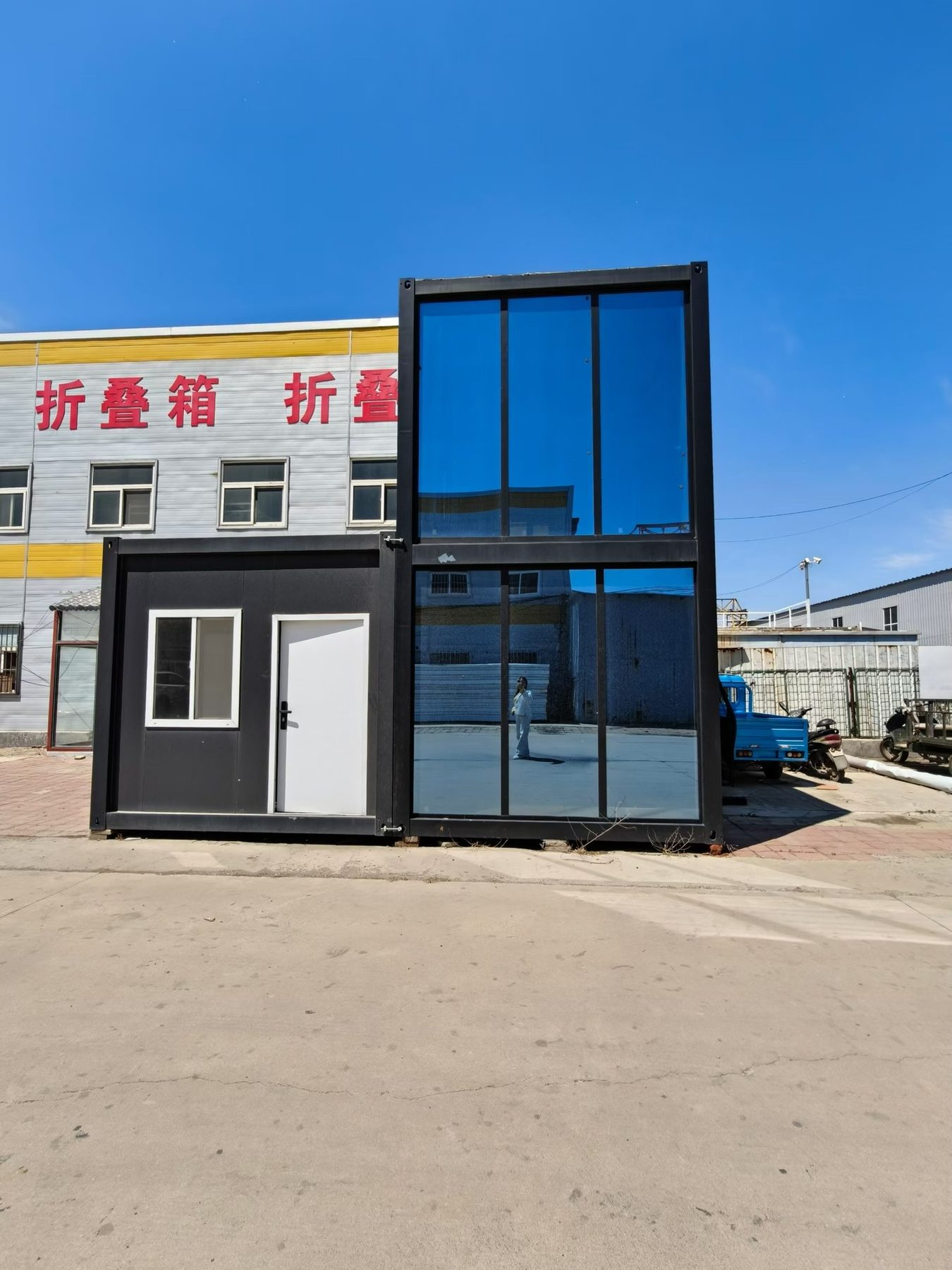 Two-storey modular house with a full-height glazed facade
